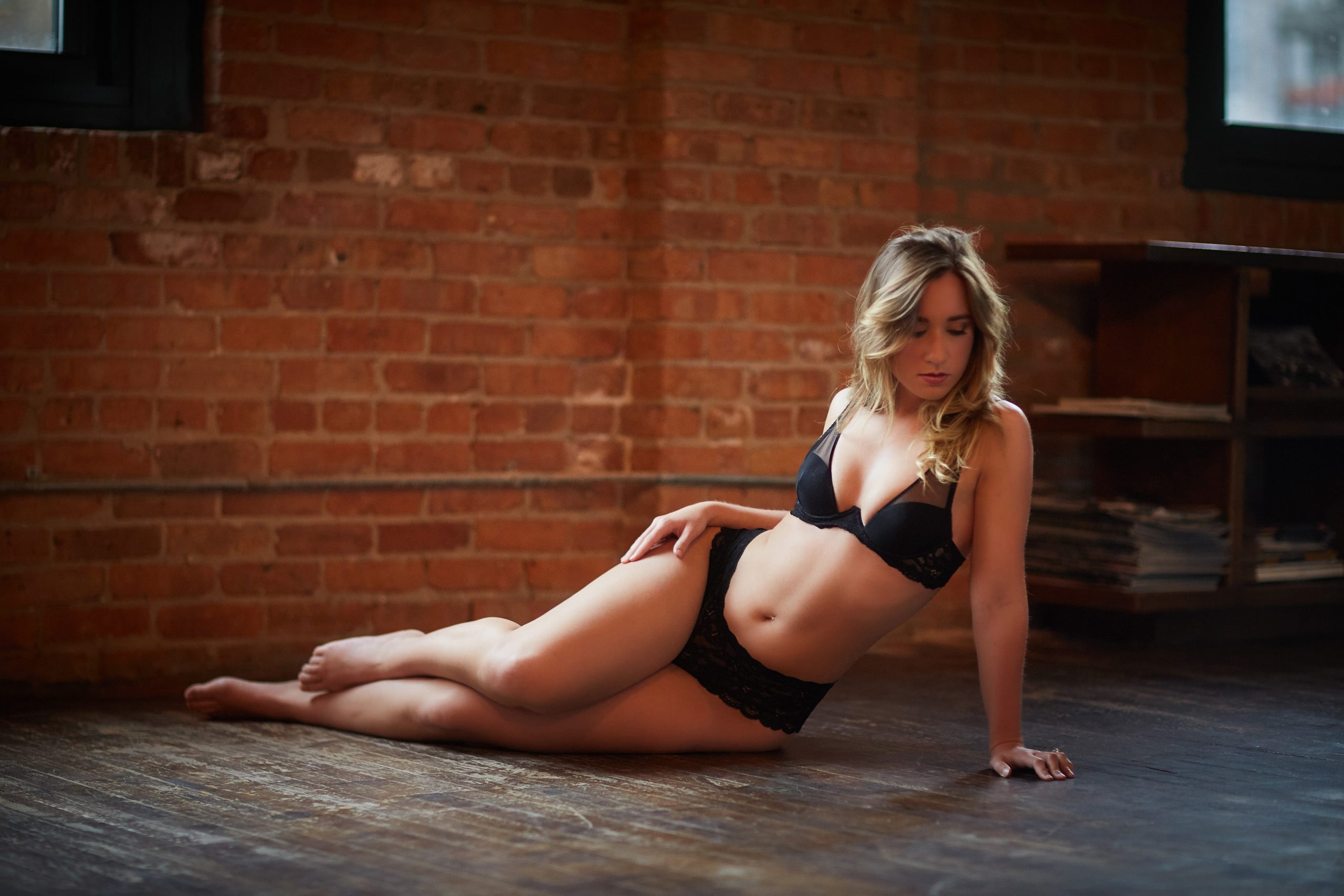 woman laying on ground in lingerie boudoir session