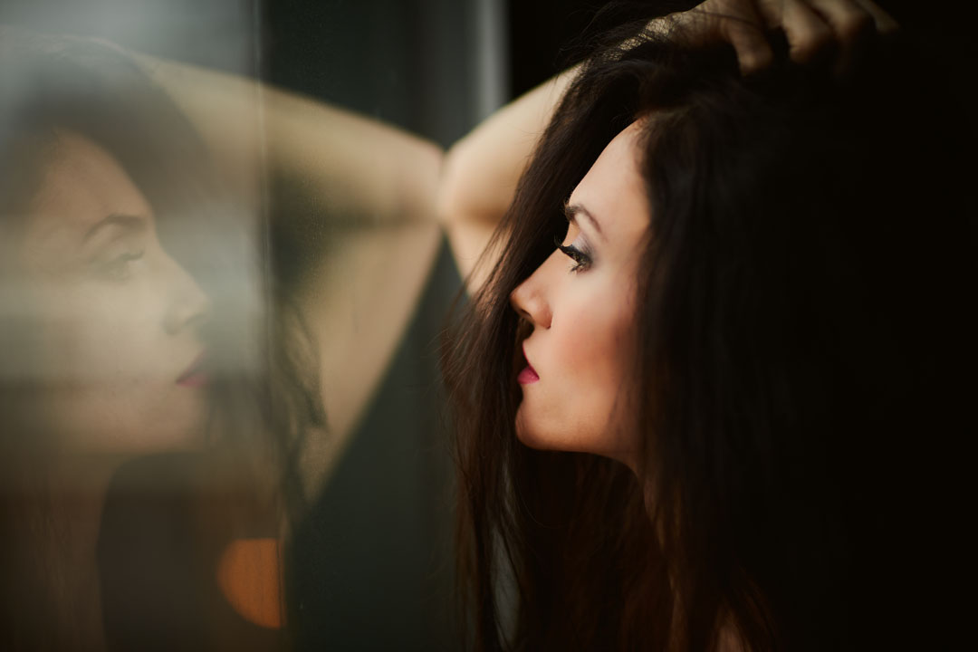 woman holding her hair looking at reflection sexy photography