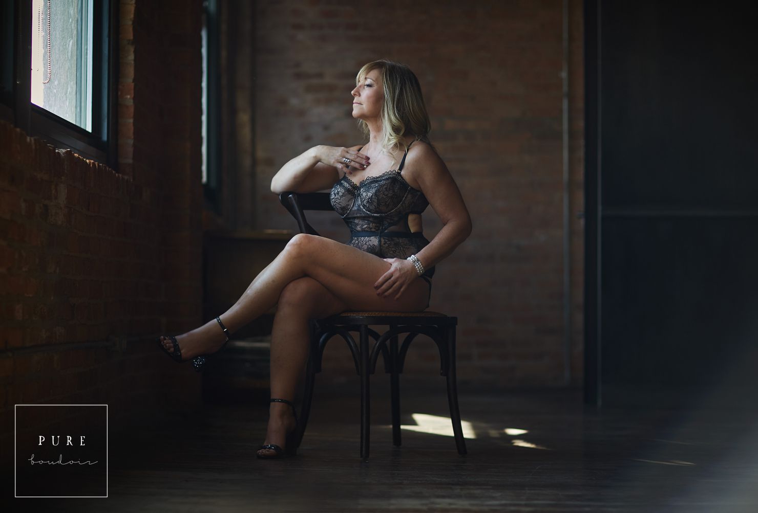 woman sitting on chair looking out the window lingerie boudoir