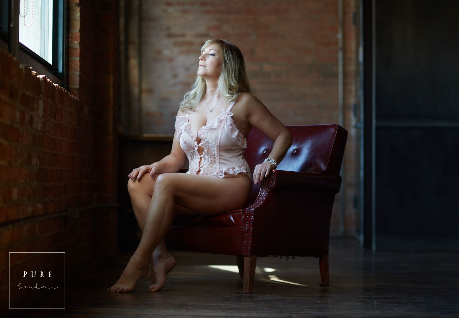 mature woman sitting on chair looking out the window chicago boudoir