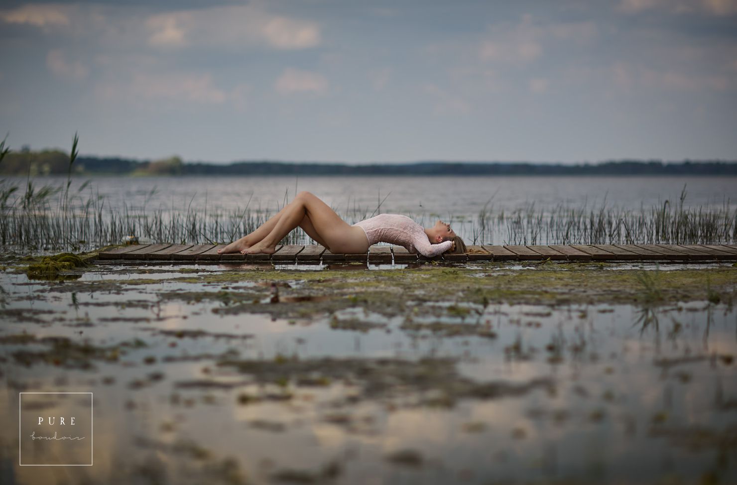 woman laying on boards near water lingerie photoshoots