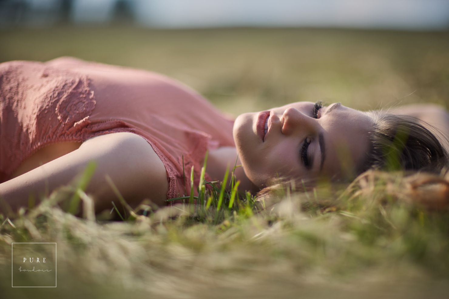 woman in boudoir lingerie laying on the ground looking into the distance