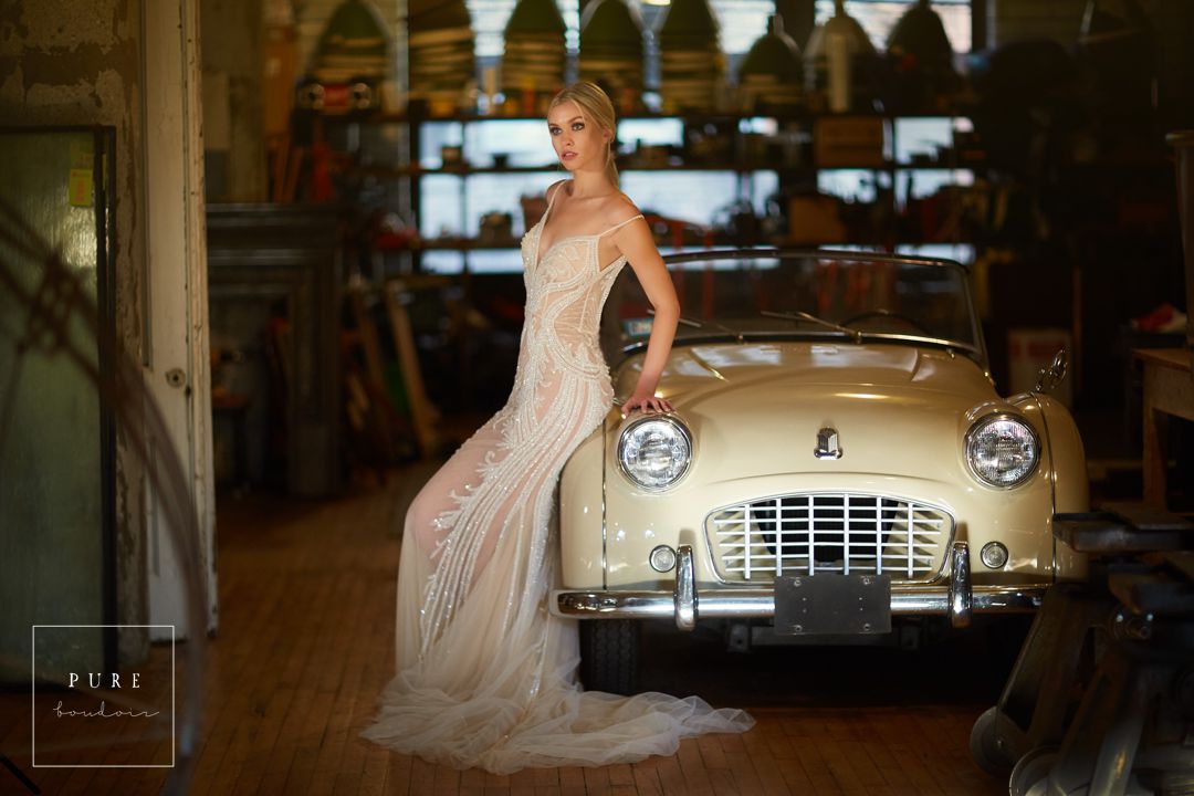 bride posing in wedding dress sitting on car chicago boudoir