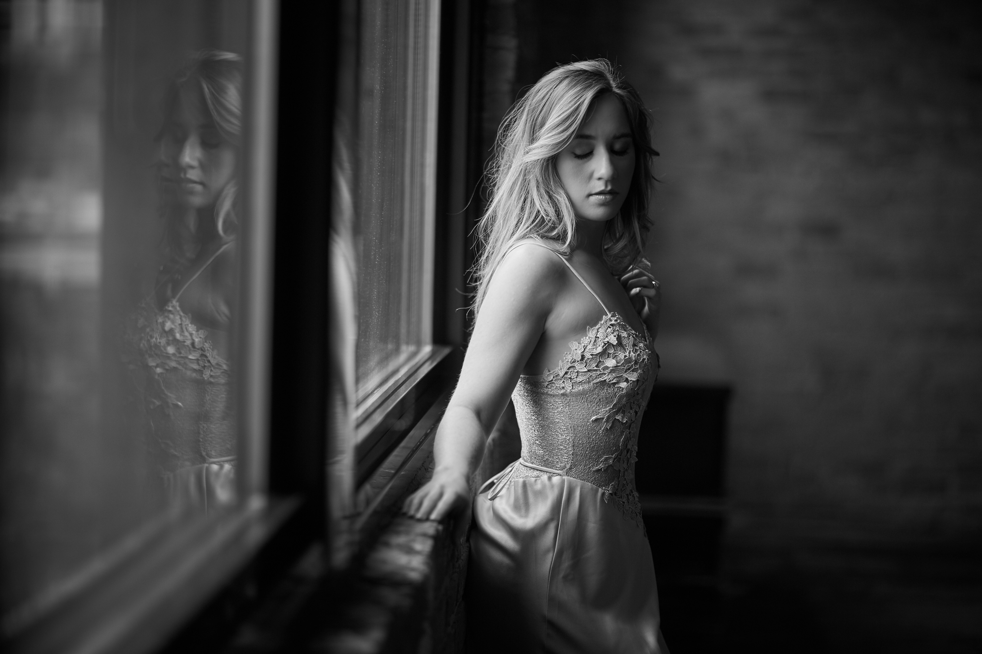 woman standing next to window sexy photography black and gray