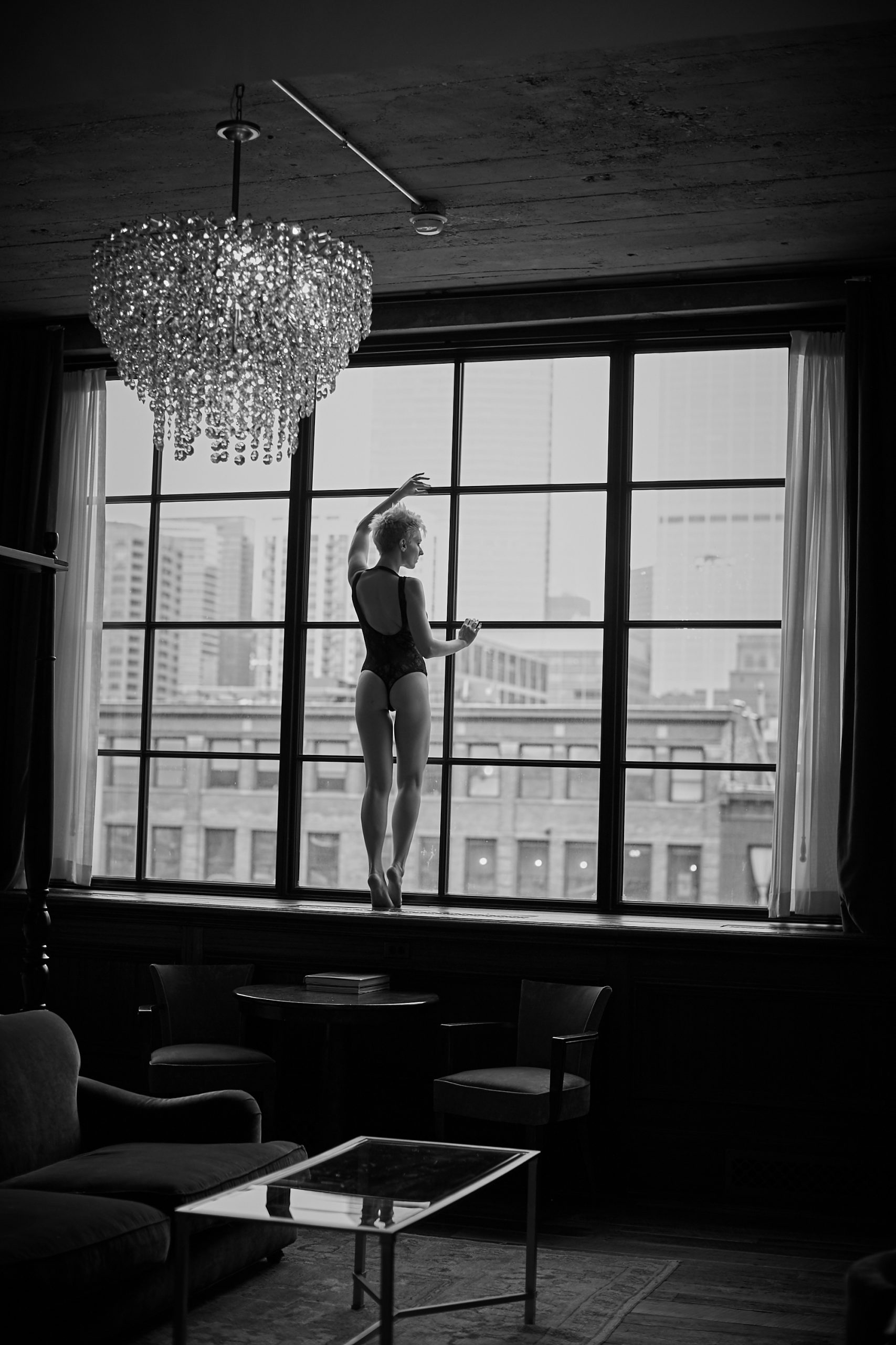 short haired woman standing on window black and white photography chicago boudoir