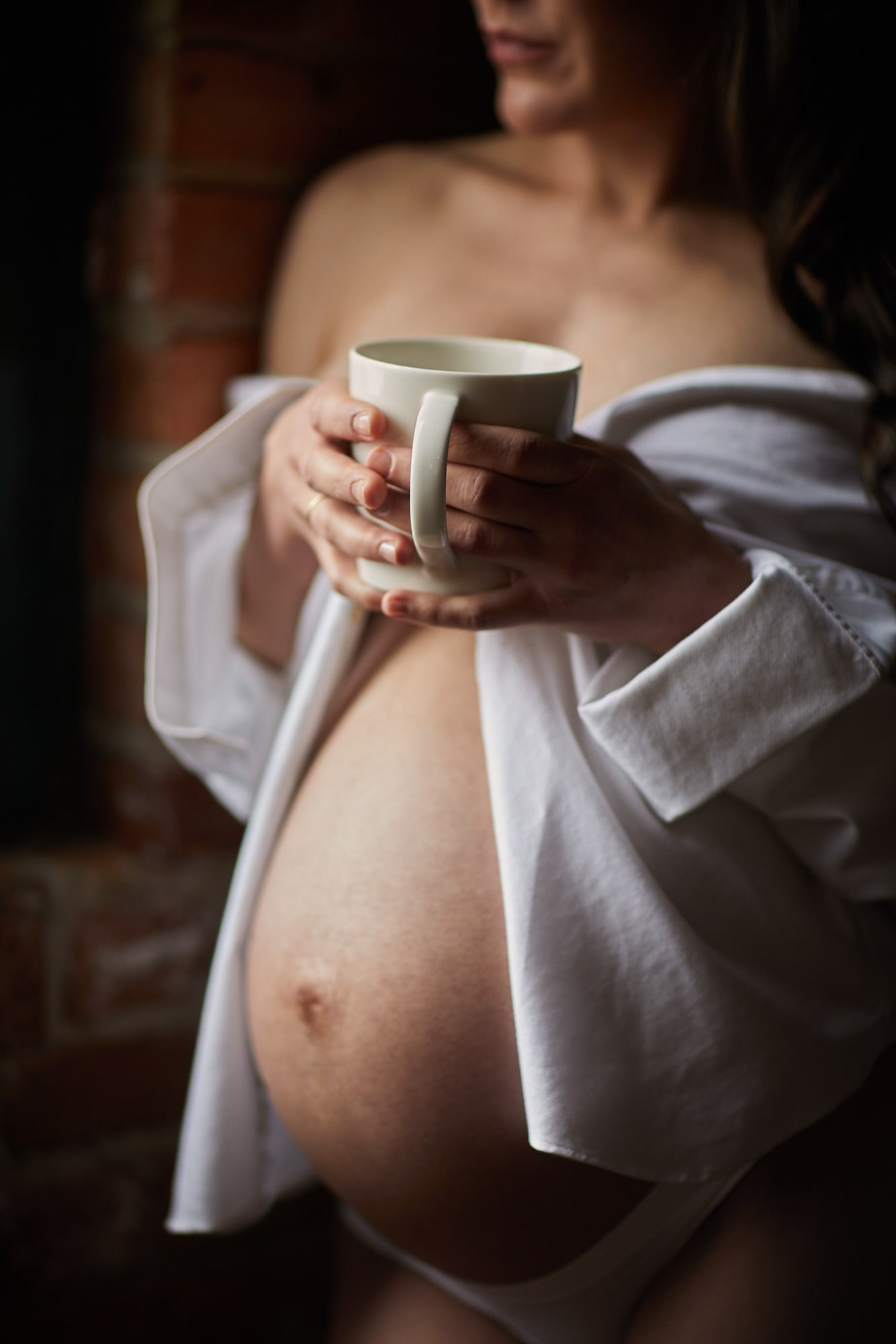 woman holding coffee mug maternity boudoir session chicago